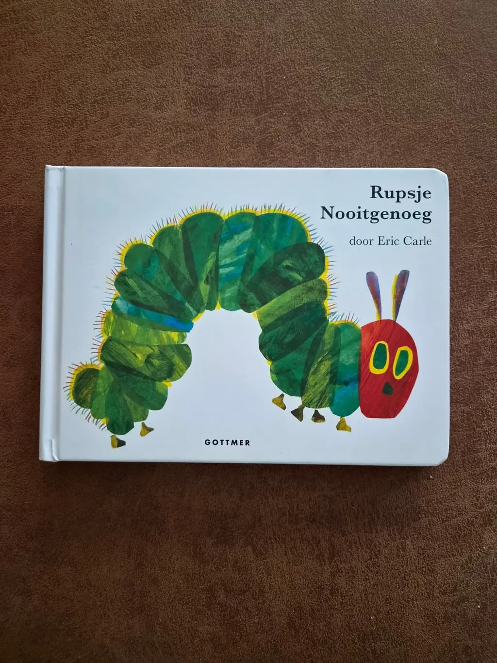 The board book "Rupsje Nooitgenoeg" (The Very Hungry Caterpillar) by Eric Carle