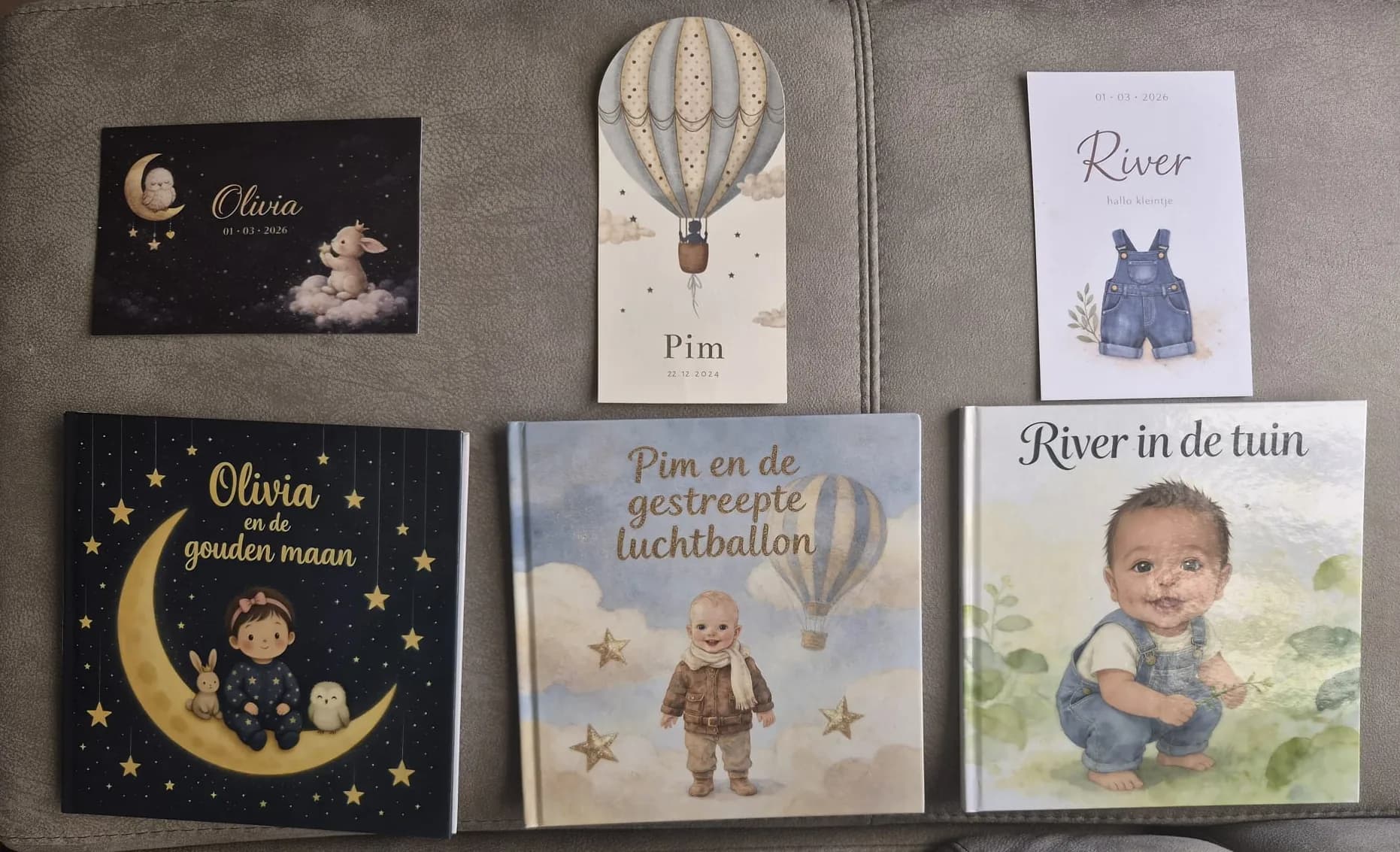 Drie gedrukte gepersonaliseerde kinderboeken naast de geboortekaartjes die als inspiratie dienden