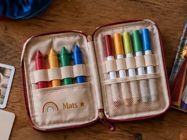 Geopende tekenset met waskrijtjes, stiften en de naam Mats